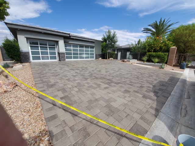 Gray paver driveway taped off after sealing