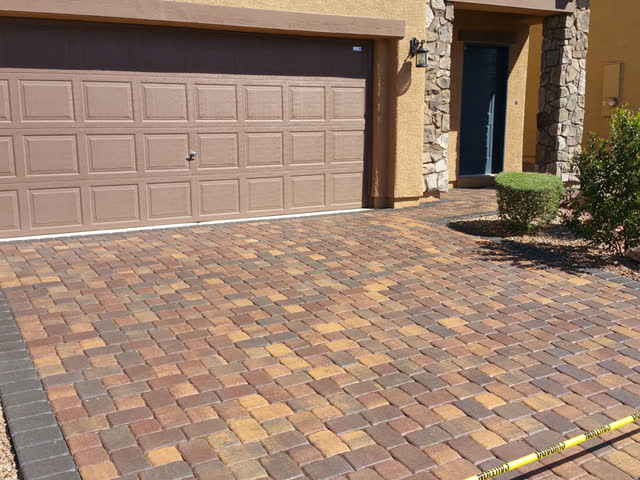 New paver driveway taped off after sealing
