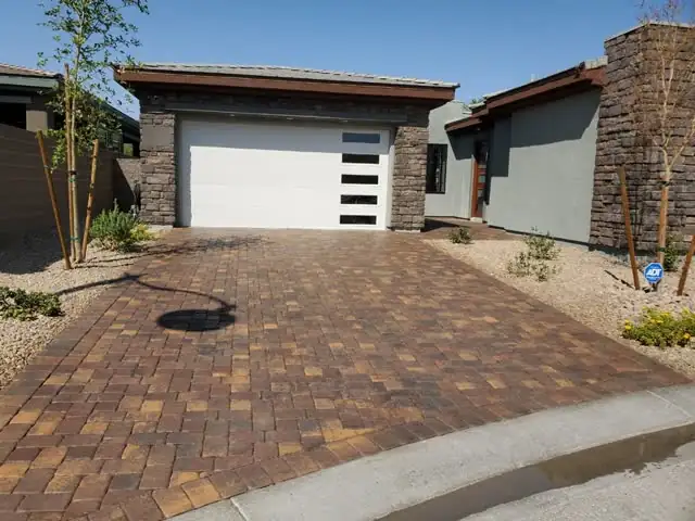 Paver driveway at a modern stone-front home